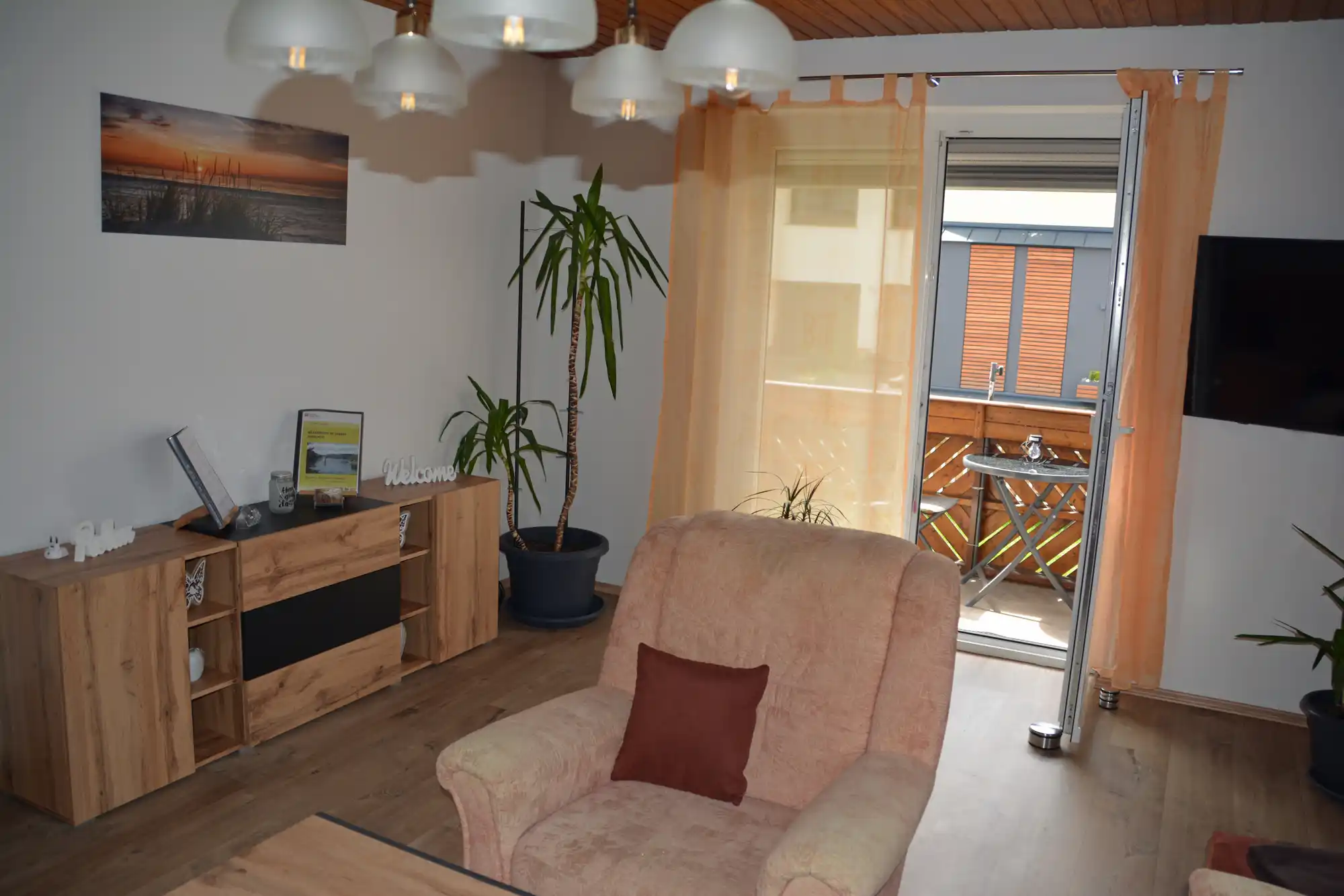 Ein kleiner Balkon mit einem Tisch und Stühlen befindet sich direkt am Wohnzimmer.